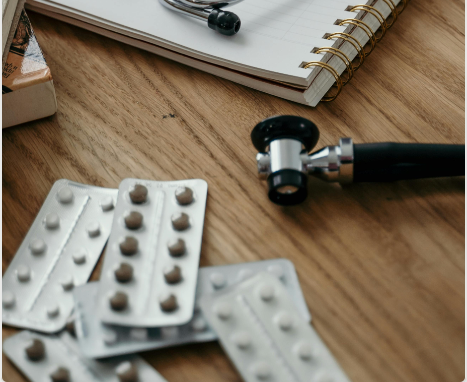 Schreibtisch beim Arzt mit unterschiedlichen Pillenpackungen auf dem Tisch