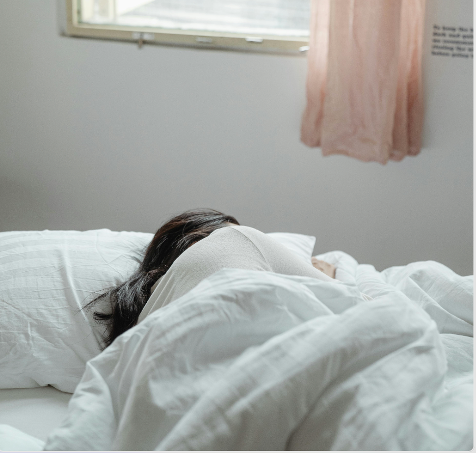 Frau liegt im Bett und ist traurig