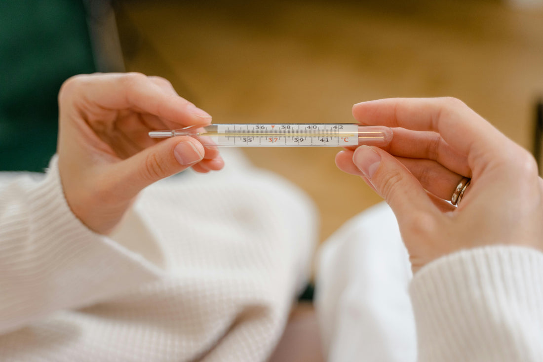 Frau mit Kinderwunsch oder hormonfreier Verhütung schaut auf Thermometer